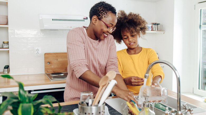 A woman and teenager washing dishes together