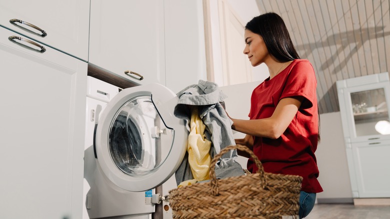 Woman putting washing in machine