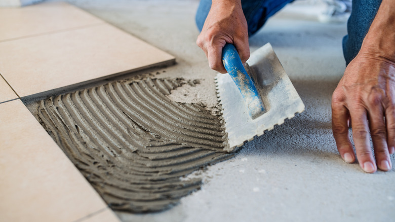 A person laying tiles