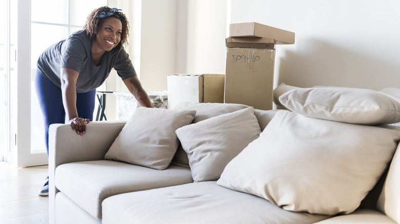 woman pushing a couch