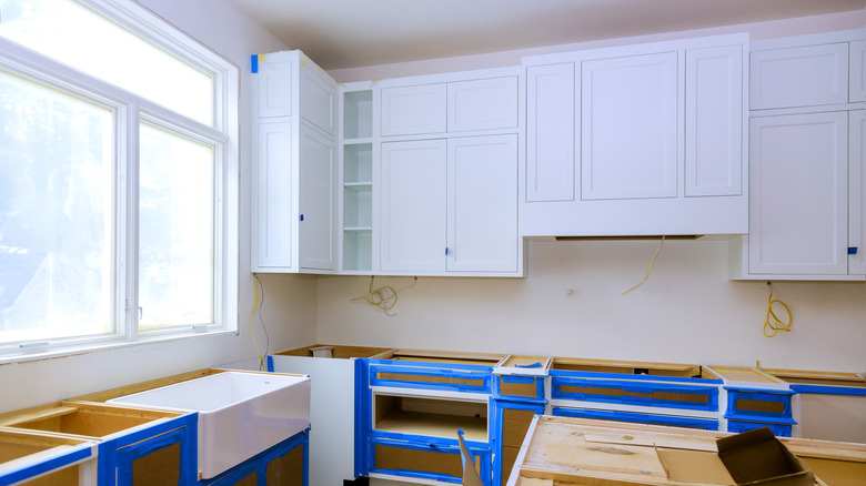 Kitchen with wood cabinets being painted white