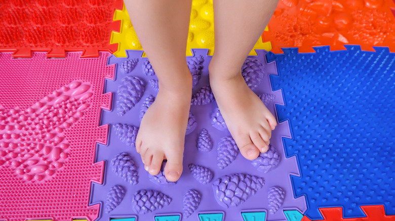 Child standing on rubber mat