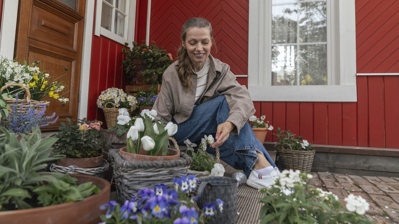 Person sitting near flower pots on the deck