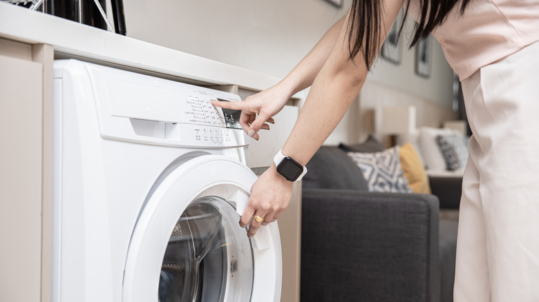 woman changing washer settings on control panel