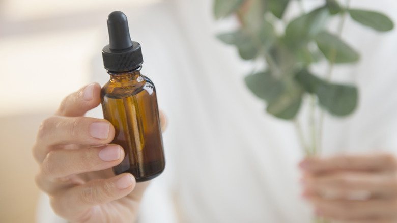 person holding essential oil bottle