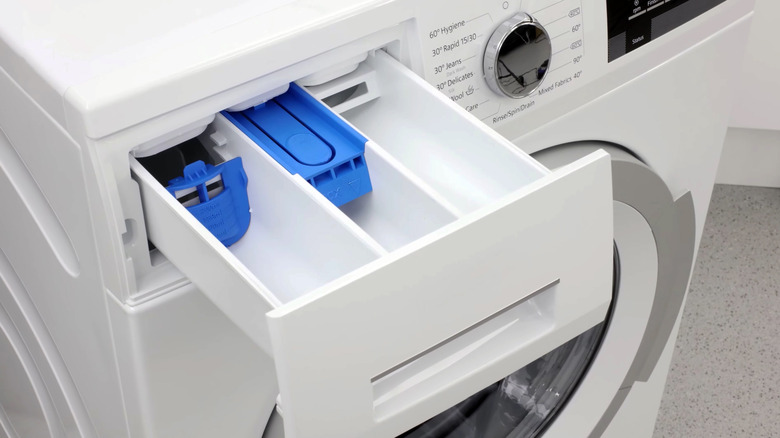 white washing machine with open dispenser