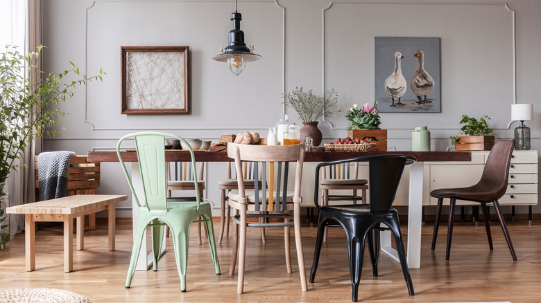 table surrounded by different chairs