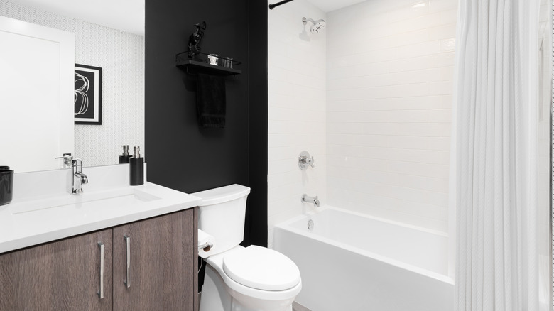 Neutral modern bathroom with a black wall behind the toilet