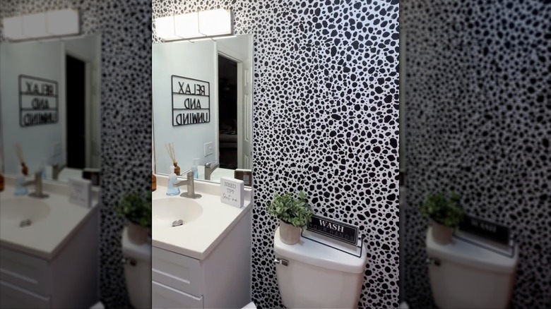 Stamped black paint in a patterned design on bathroom wall