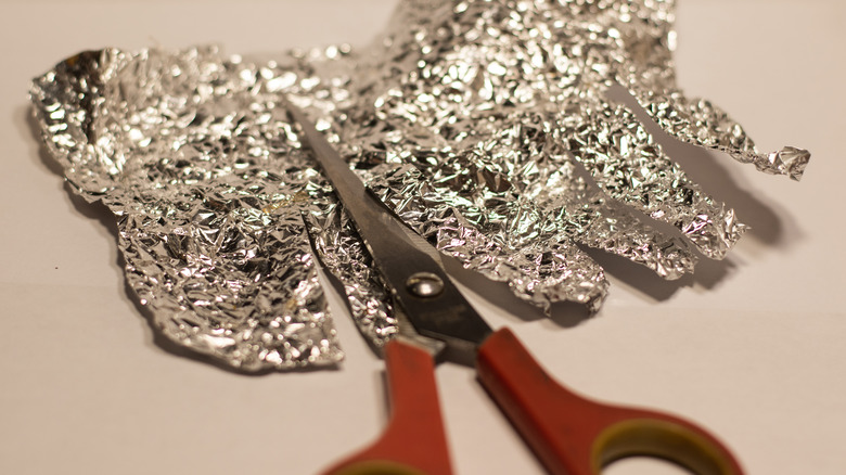 scissors cutting aluminum foil strips