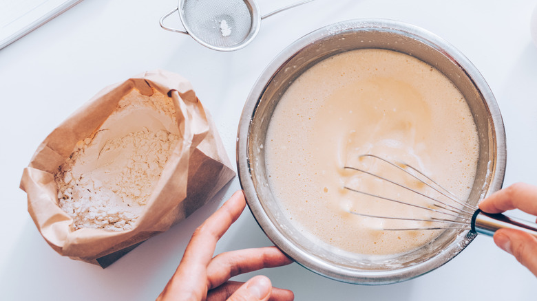 person mixing flour in bowl