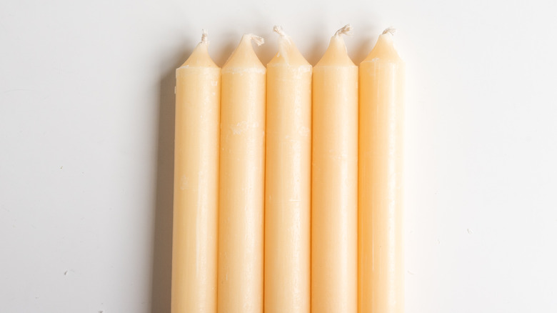 five yellow unlit candles