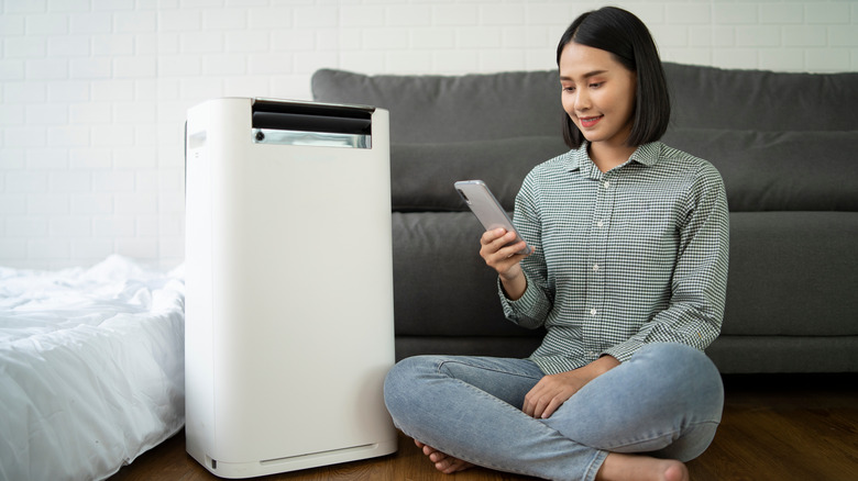 woman using dehumidifier at home 