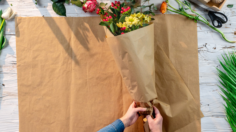 woman wrapping flowers with paper