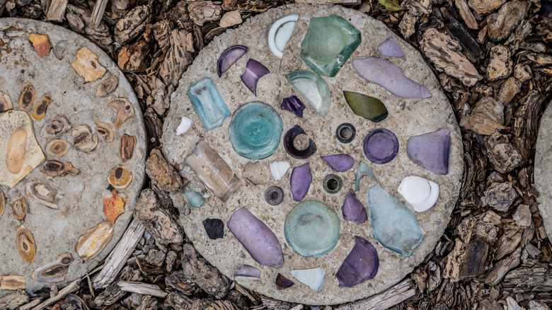 a concrete stepping stone with broken glass decorations