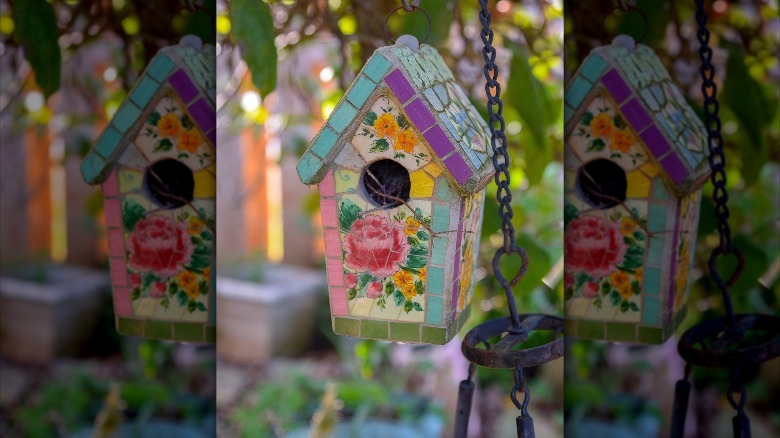 bright colored broken China birdhouse in yard