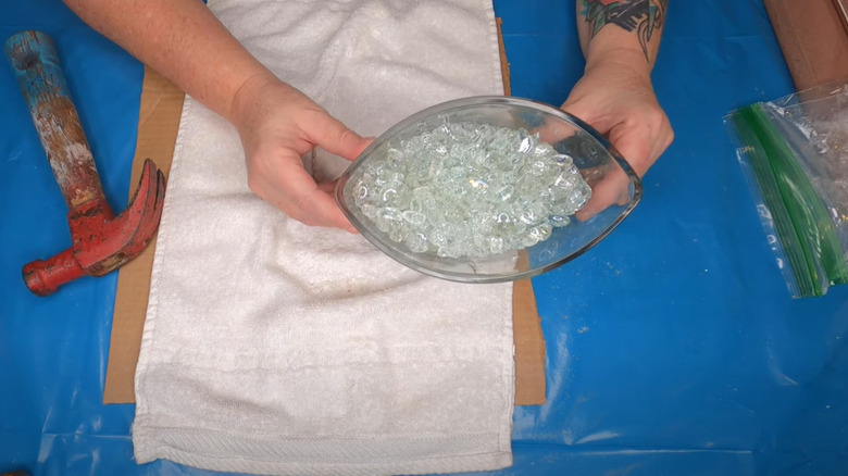 hands holding vase with crushed glass