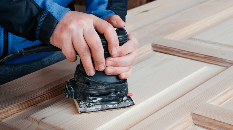 Person sanding a closet door