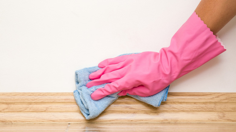 cleaning baseboards with microfiber cloth 