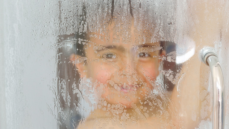 child in fogged up shower