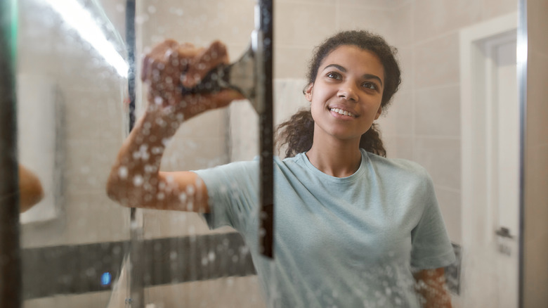 person using shower squeegee