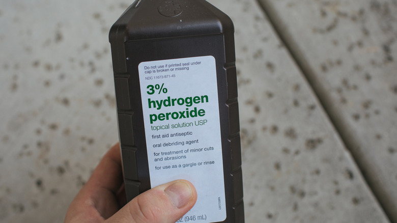 holding bottle of Hydrogen peroxide