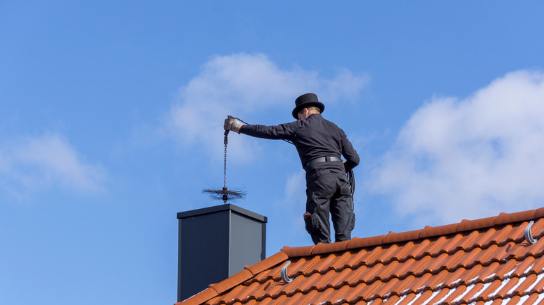 chimney cleaner lowering an item into flue