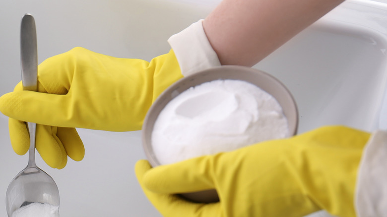 gloved hands holding baking soda