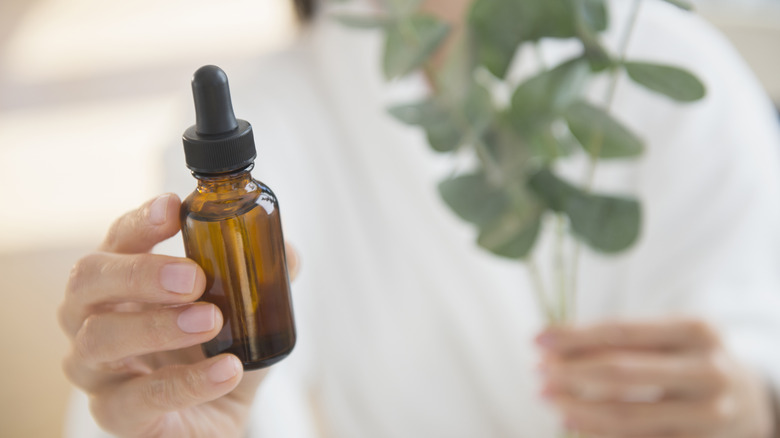 Woman holding eucalyptus oil bottle