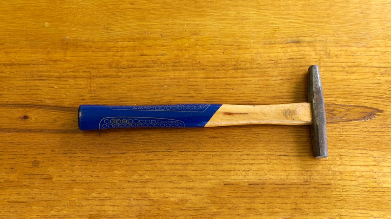 Tack hammer on wood background