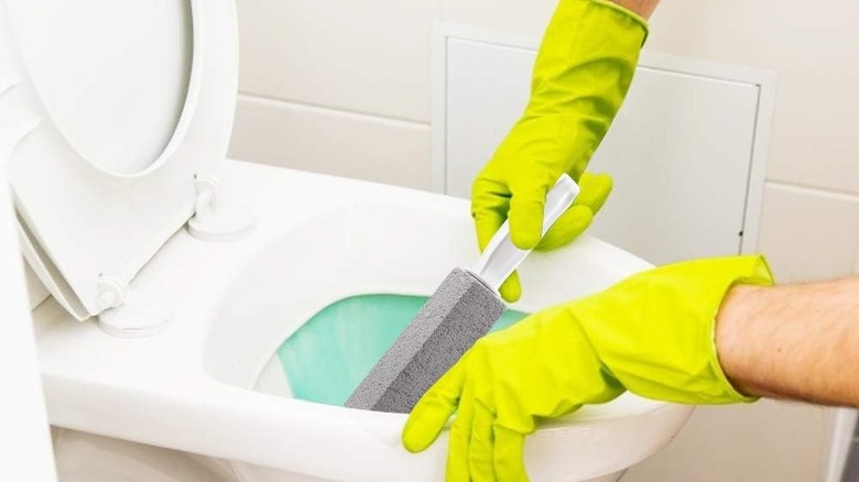 Cleaning toilet with pumice stick 