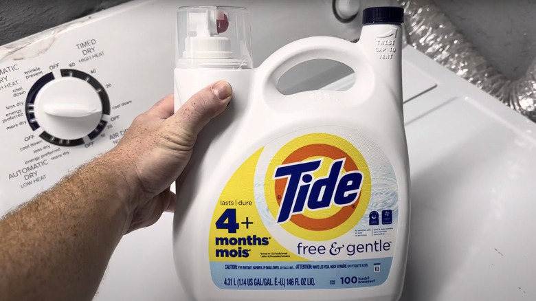 Man holding Tide free & gentle detergent