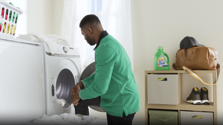 Man putting towels in dryer