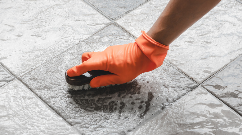 orange glove cleaning floor tile