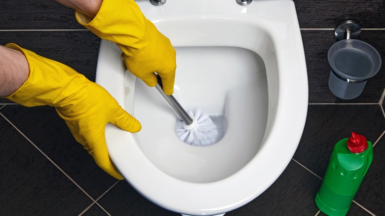 yellow gloves cleaning toilet