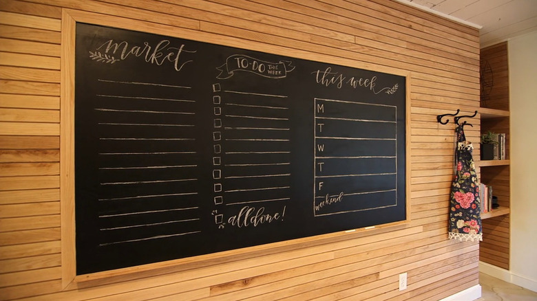 A kitchen with an accent wall covered in lath boards