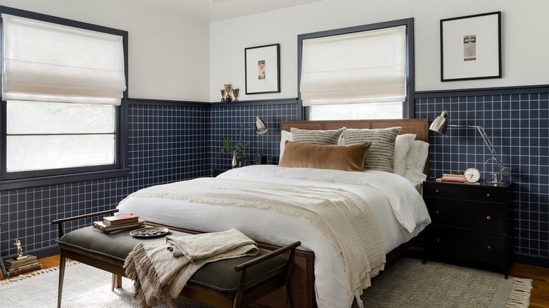 A room with a half accent wall featuring blue wallpaper