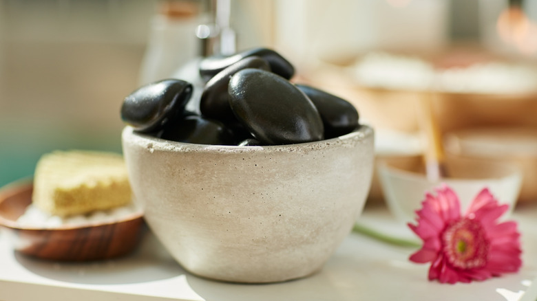 Black river rocks in a stone bowl