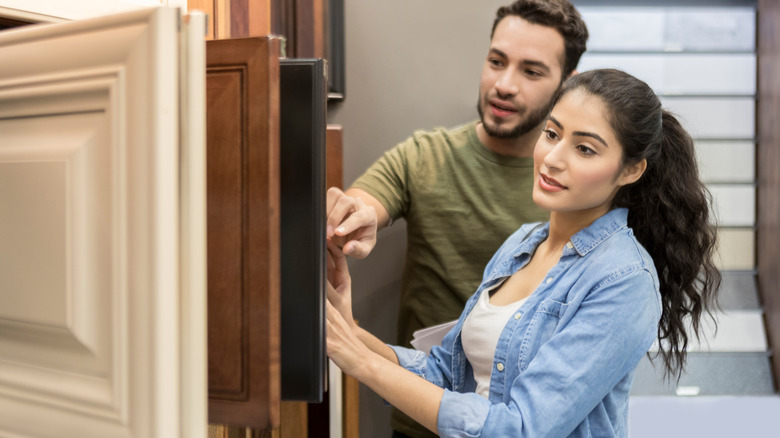 Young couple browsing a selection of kitchen cabinet fronts