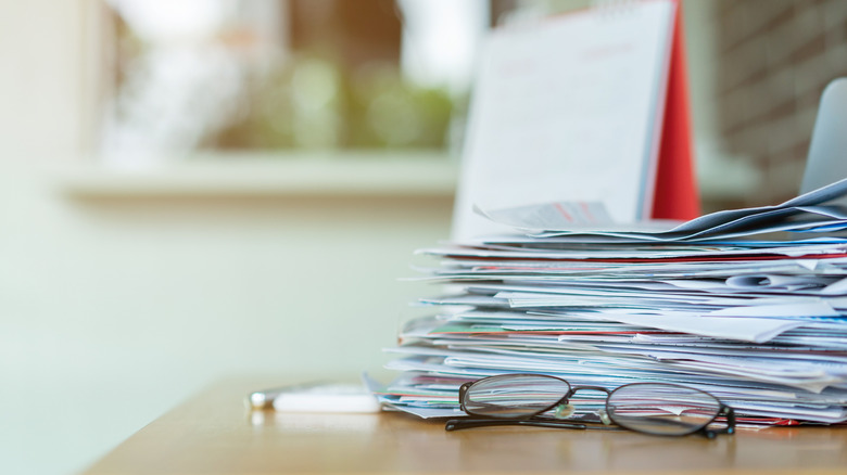 Eyeglasses in front of a stack of papers