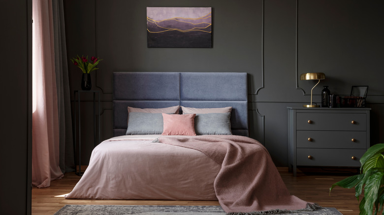 Bedroom with dark gray walls and pink accents