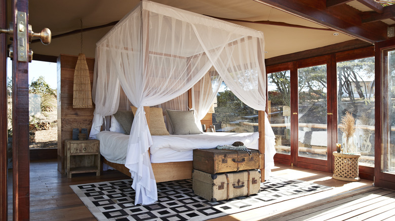 Canopy bed in a bedroom with glass windows