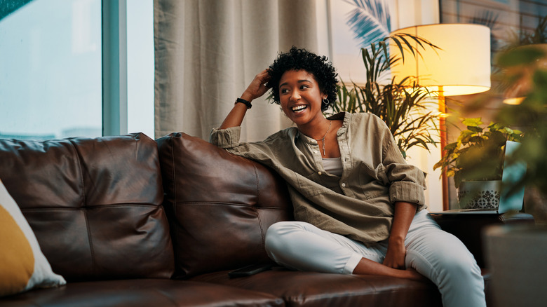 Woman sitting on a leather chair in living room