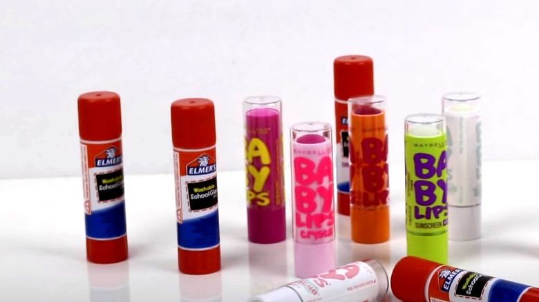 Glue sticks and lip balm tubes grouped together on a table.