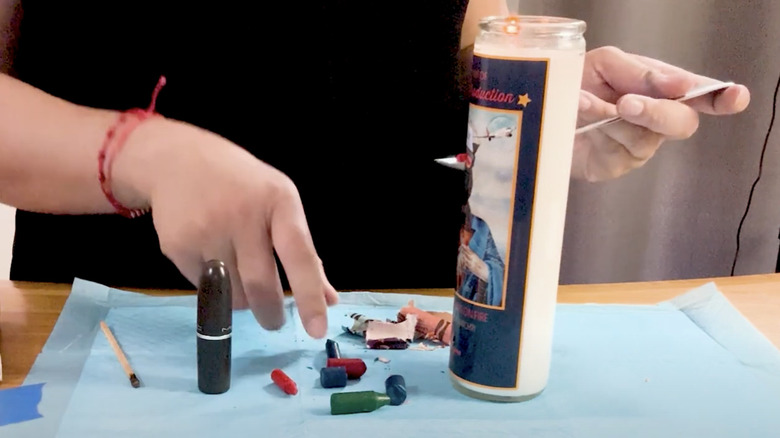 Woman melting crayons and pouring them into an old lip balm tube.