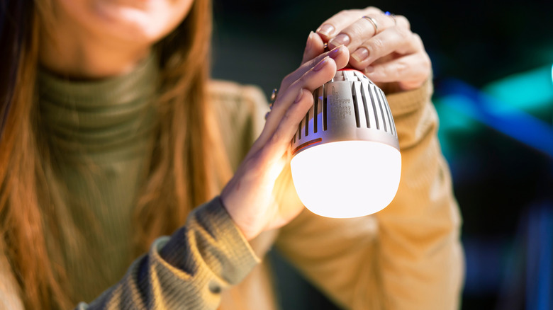 Person holding a smart light bulb