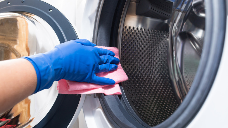 person cleaning washing machine