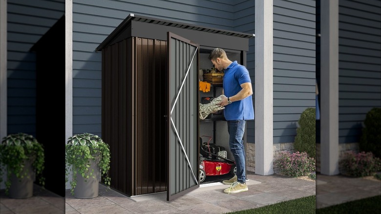 A man stores rope in a black and brown shed