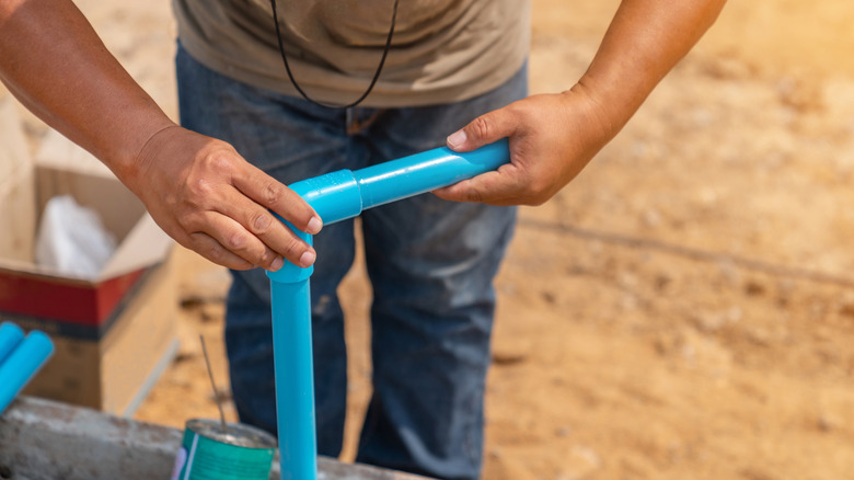 A person gluing PVC pipes together