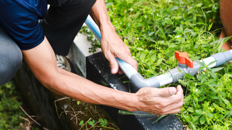 A person connecting two PVC pipes